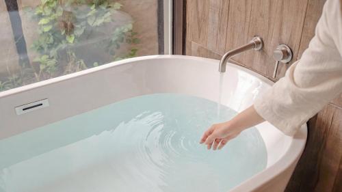 a person washing their hand in a bath tub at gyeongju planb pet pension in Gyeongju