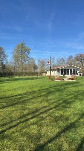 a large field with a flag in front of a building at Chalet Achterbosch in Lieshout