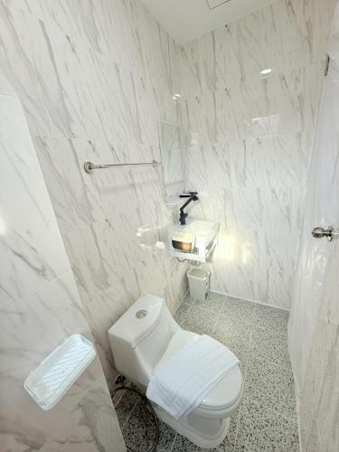 a white bathroom with a toilet and a sink at Dana Residence in Ko Yao Noi