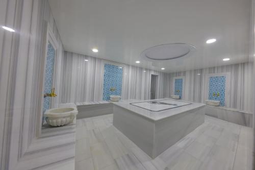 ein weißes Badezimmer mit Badewanne und Waschbecken in der Unterkunft The Nava Hotel in Bostaniçi