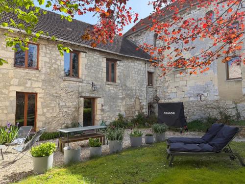 a building with a table and a chair in the yard at Maison de famille du 17ème siècle I Proche Senlis Chantilly Compiègne Astérix Paris in Pontpoint