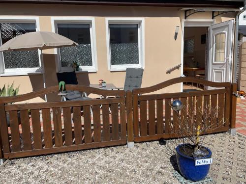 a porch with a wooden fence and an umbrella at Ferienwohnung in der Seestraße in Sassnitz