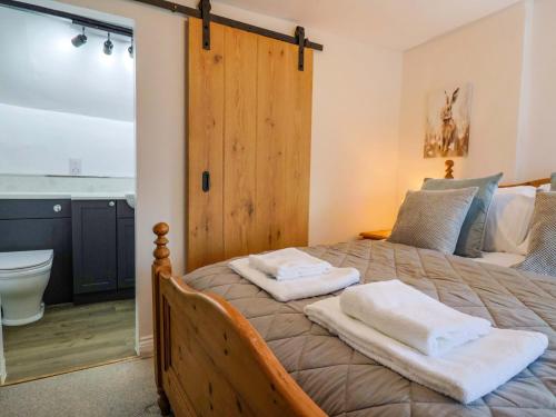 a bedroom with a bed with two towels on it at Bridge Cottage in Bridport