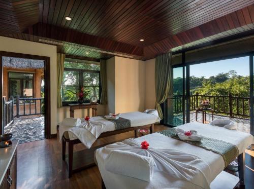 a room with three beds and a balcony at Katiliya Park Villa in Mae Chan