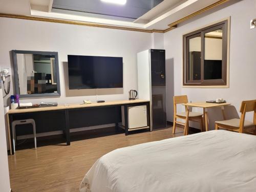 a bedroom with a bed and a desk with a tv at 호텔야자 담양점 신관 in Kasan-ni