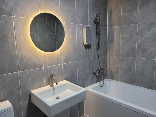 a bathroom with a sink and a tub and a mirror at 호텔야자 담양점 신관 in Kasan-ni