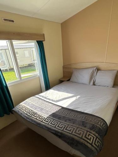 a bed in a small room with a window at Seaside views in North Seaton