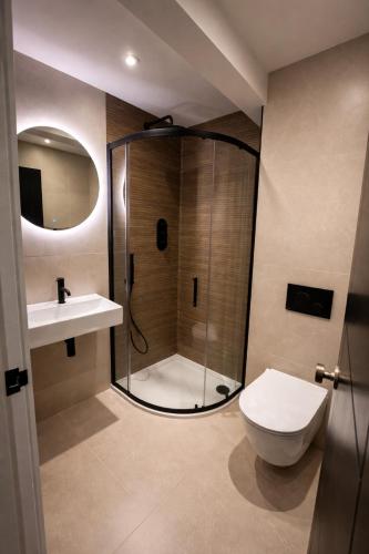 a bathroom with a shower and a toilet and a sink at Glass Tower - By Central Beach Leisure in Blackpool
