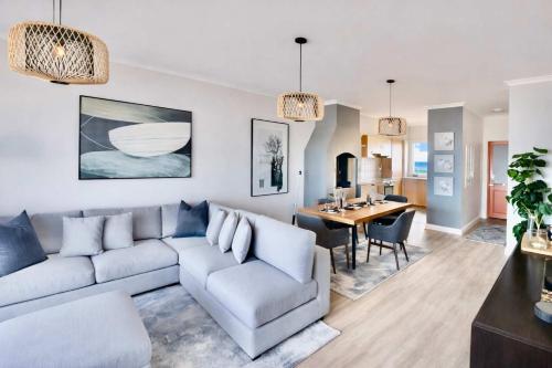 a living room with a couch and a dining room at Sunset View 23 in Langstrand