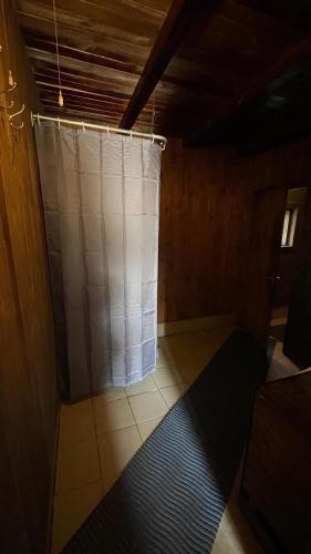 a bathroom with a shower curtain in a room at Lauku sēta Svētupes in Salacgrīva