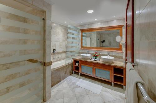 a bathroom with two sinks and a mirror at Donatello Hotel in Dubai