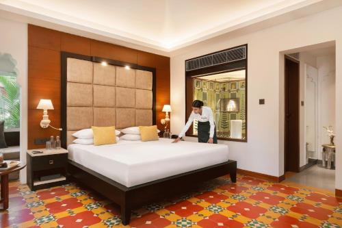 a person making a bed in a hotel room at Gateway Kandla Gandhidham in Gandhidham