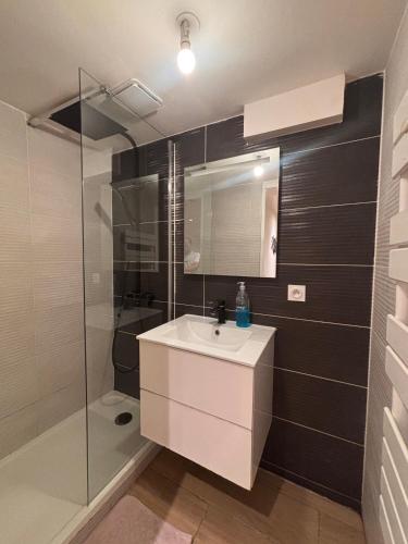 a bathroom with a sink and a shower at La maison penchée in Rosny-sous-Bois