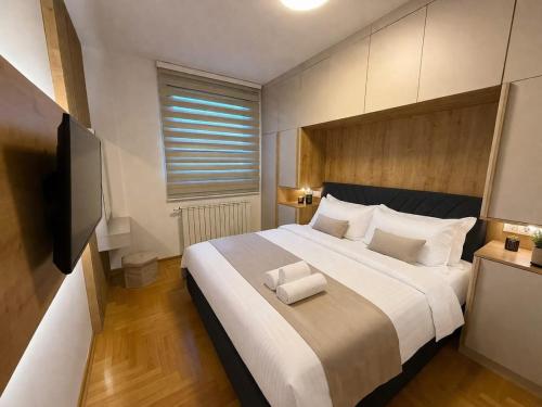 a bedroom with a large bed and a television at Zozo's Apartment in Sarajevo