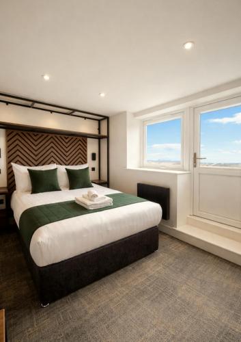 a bedroom with a large bed and two windows at Glass Tower - By Central Beach Leisure in Blackpool