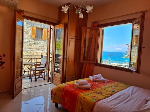 a bedroom with a bed and a view of the ocean at Avra Apartments in Leonidio