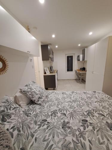 a bedroom with a large bed and a kitchen at La Parenthèse Lémantine - Studio 3 in Neuvecelle
