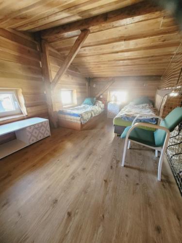 two beds in a room with wooden ceilings at Loft Szczytna in Szczytna