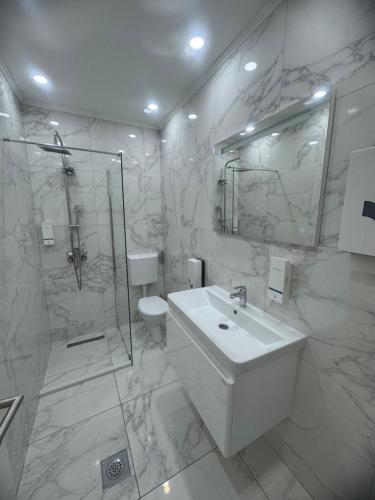a white bathroom with a sink and a shower at Motel Marco Polo in Gredice
