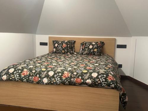 a bedroom with a bed with a floral bedspread at Villa Le Roy in Blankenberge