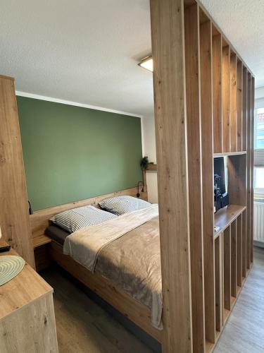 ein Schlafzimmer mit einem Bett und einer großen Holzwand in der Unterkunft Schmidteinander in Norderney