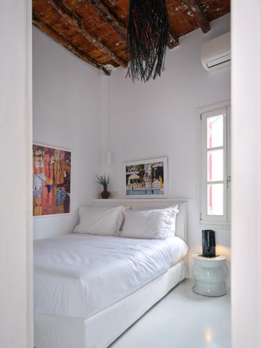 a bedroom with white walls and a white bed at Chiara Mykonos III in Mikonos