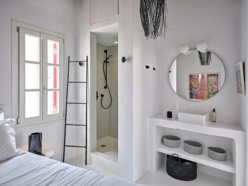 a white bedroom with a mirror and a bed at Chiara Mykonos III in Mikonos