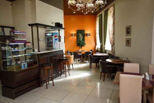 アバカンにあるHotel Druzhbaのテーブルと椅子、シャンデリアのあるレストラン