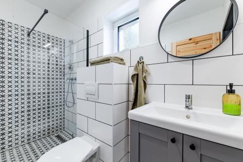 a white bathroom with a sink and a mirror at gardenSTUDIO in Děčín