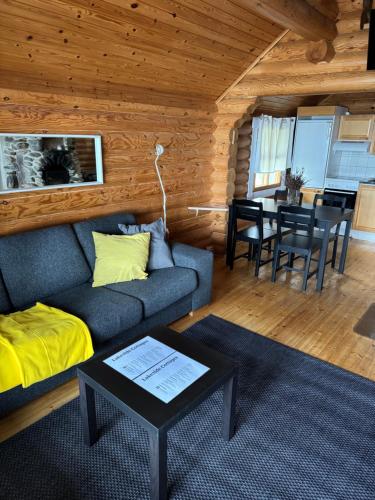 a living room with a couch and a table at Lakeside Cottages in Rastinniemi