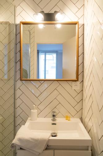 a bathroom with a sink and a mirror at Studio haut de gamme - Hypercentre - Lit Queen in Caen