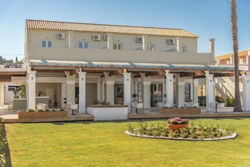 a large house with a garden in front of it at Ionian Blue Beach Hotel - Adults Only in Kavos