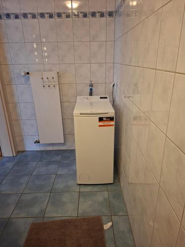 a small white refrigerator in a room with a door at Ferienwohnung in Bad Schwalbach in Bad Schwalbach