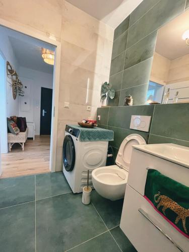 a bathroom with a toilet and a washing machine at Angel's Home in Dunajská Streda