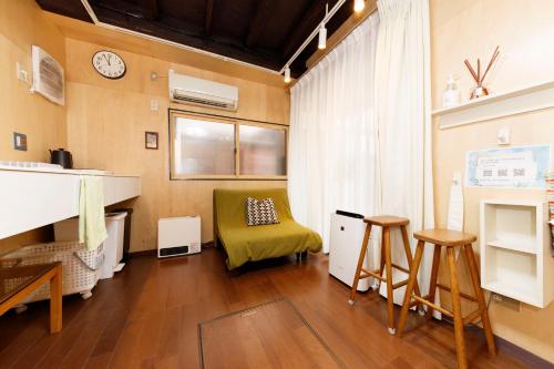 a living room with a green chair and a table at May Guest House in Tokyo