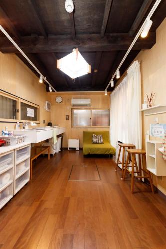 a large kitchen with a green couch in a room at May Guest House in Tokyo