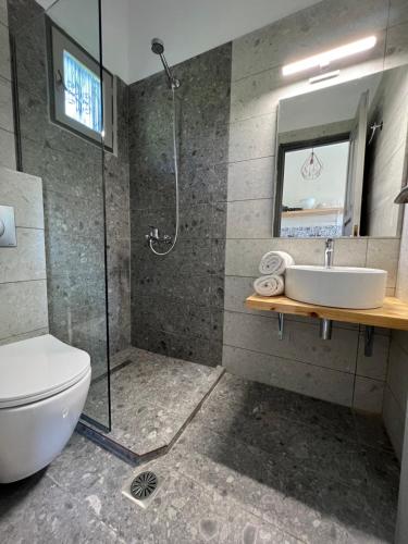 a bathroom with a shower and a toilet and a sink at Ninemo Residences Skiathos in Achladies