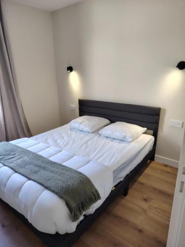 a bedroom with a bed with white sheets and pillows at Logement 2 cité de caractère in Mallièvre
