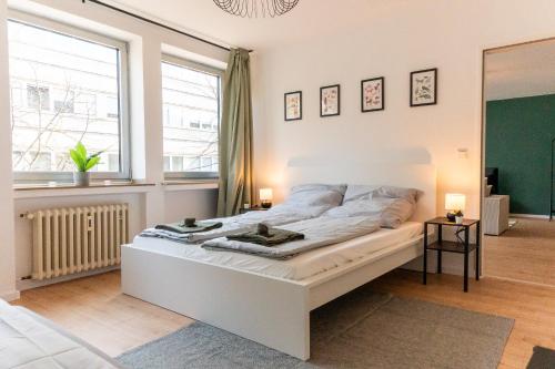 a white bed in a room with a window at Modernes Apartment im Essener Stadtkern mit Parkplatz in Essen