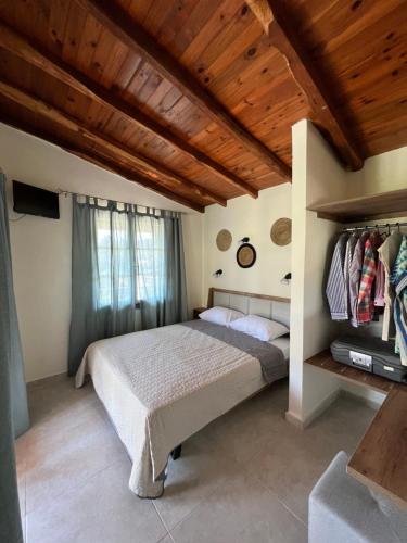 a bedroom with a bed and a wooden ceiling at Ninemo Residences Skiathos in Achladies