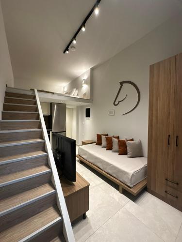 a bedroom with a bed and a staircase with a tv at Modern Lofts in Archangelos Rhodes with Parking - Equus - 3 Guests in Archangelos