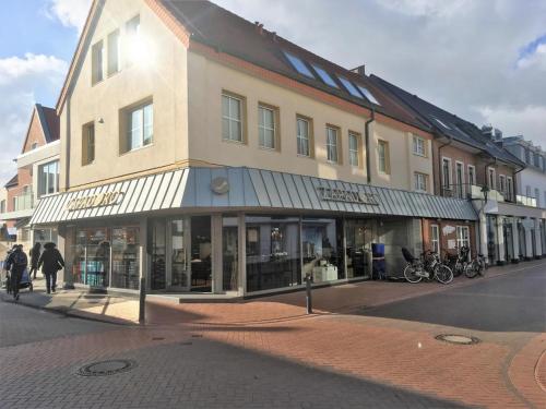 ein Gebäude in einer Stadtstraße, an dem Menschen vorbeigehen in der Unterkunft Schmidt-einander W 8 in Norderney