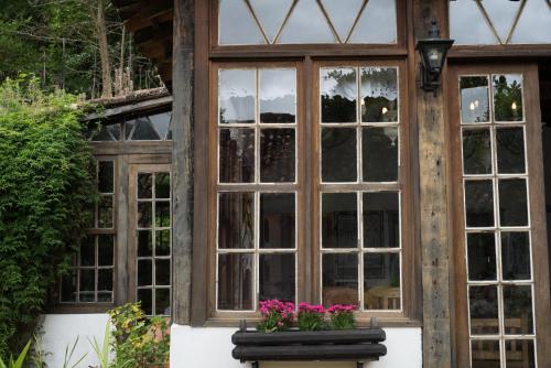 a window of a house with pink flowers in front at Pousada da Bia in Tiradentes