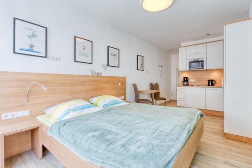 a bedroom with a large bed and a kitchen at Alte Teestube Schmidt 68 in Norderney