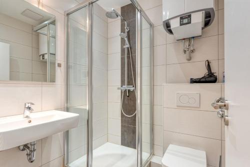 a bathroom with a shower and a sink at Alte Teestube Schmidt 68 in Norderney