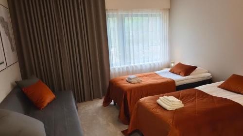 a hotel room with two beds and a window at Polku Hotelli in Vihti