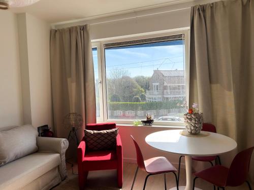 a living room with a table and a large window at Strandhuis Scheveningen - Studio Apartments in Scheveningen