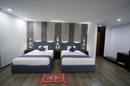 a bedroom with two beds and a piano at Hotel Crown Park Ltd in Sylhet
