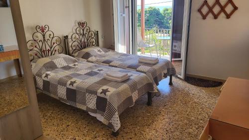 a bedroom with two beds and a balcony at Filippos Apartments "Room 5" in Spartià