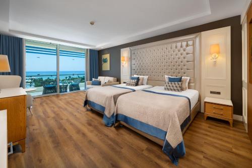 a bedroom with a large bed and a large window at Sueno Hotels Deluxe Belek in Belek